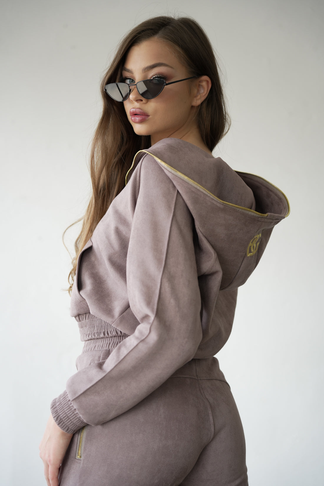 Modelka relaxujúca v dámskej semišovej súprave BG Couture New Essentials počas voľného dňa.